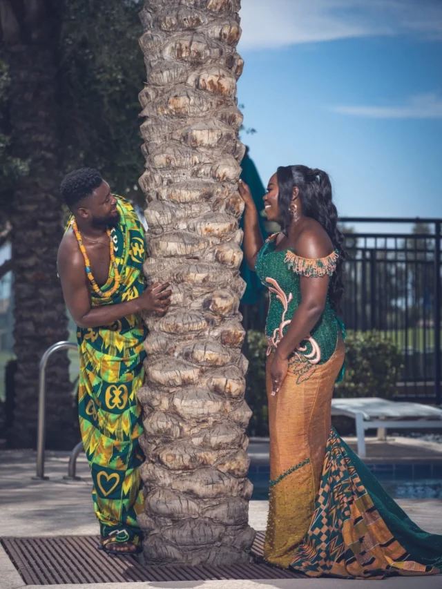 Couple in traditional attire by a palm